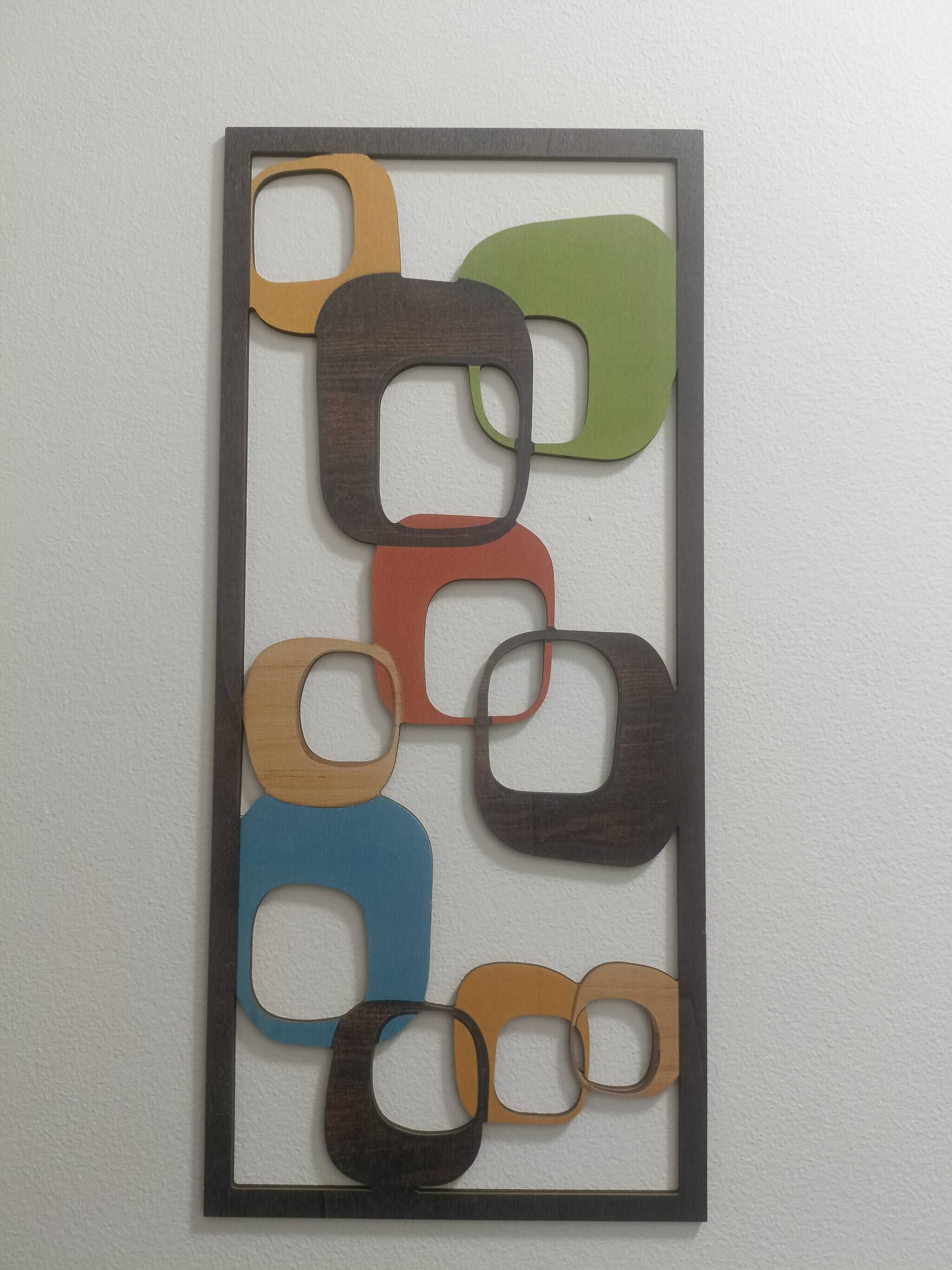 A wall-mounted abstract art piece with geometric shapes in various colors.