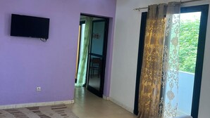 Una sala moderna con un sofá, un televisor de pantalla plana e iluminación empotrada en el techo.