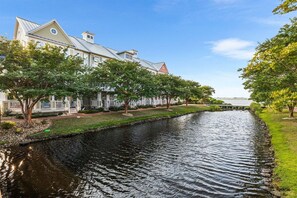 Ein Kanal mit einer Reihe von Bäumen und einem Gebäude mit einem Giebel.