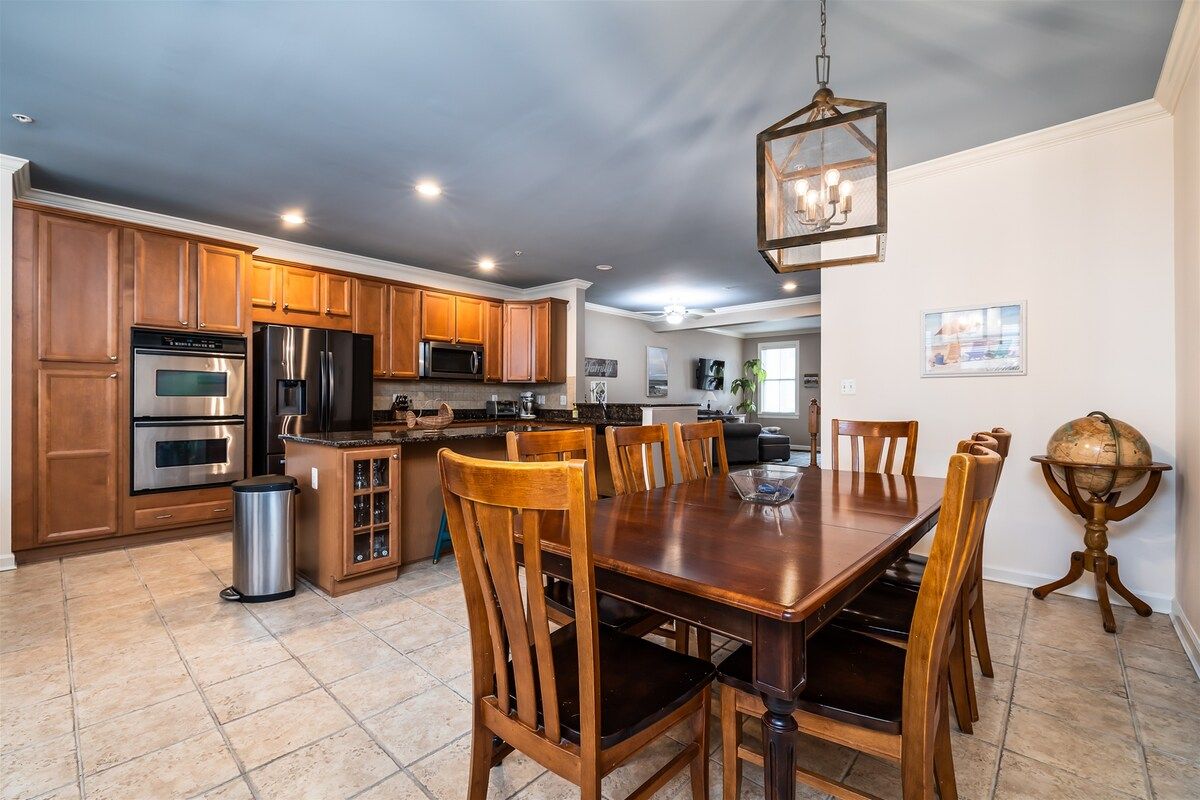 A spacious kitchen with wooden cabinets, stainless steel appliances, and a dining area with a large wooden table and chairs.