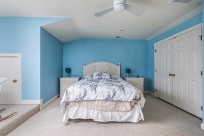 A bedroom with a bed, nightstands, a ceiling fan, and a wardrobe. - Mini Weeks Stays Available Sunset Island 40 Sunset (Ocean City)