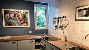 A modern kitchen with a wooden countertop, stainless steel sink, and a window with a view of greenery. - Haus Am Apfelweg – Apartment Jonagold, 70 sqm, lake view, private terrace, Wi-Fi (Immenstaad am Bodensee)