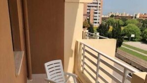 A balcony with two white plastic chairs and a metal railing. - The Sailor's house (Alghero)