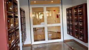 Un couloir avec une porte vitrée donnant sur une pièce, de part et d’autre de laquelle se trouvent deux rangées d’armoires de rangement en bois.