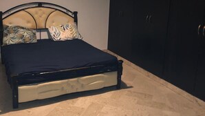 A bedroom with a bed, a headboard, a wardrobe, and a floor lamp. - Spacious  3-bedroom apartment in excellent Rabat Near Tram & City Center (Rabat)