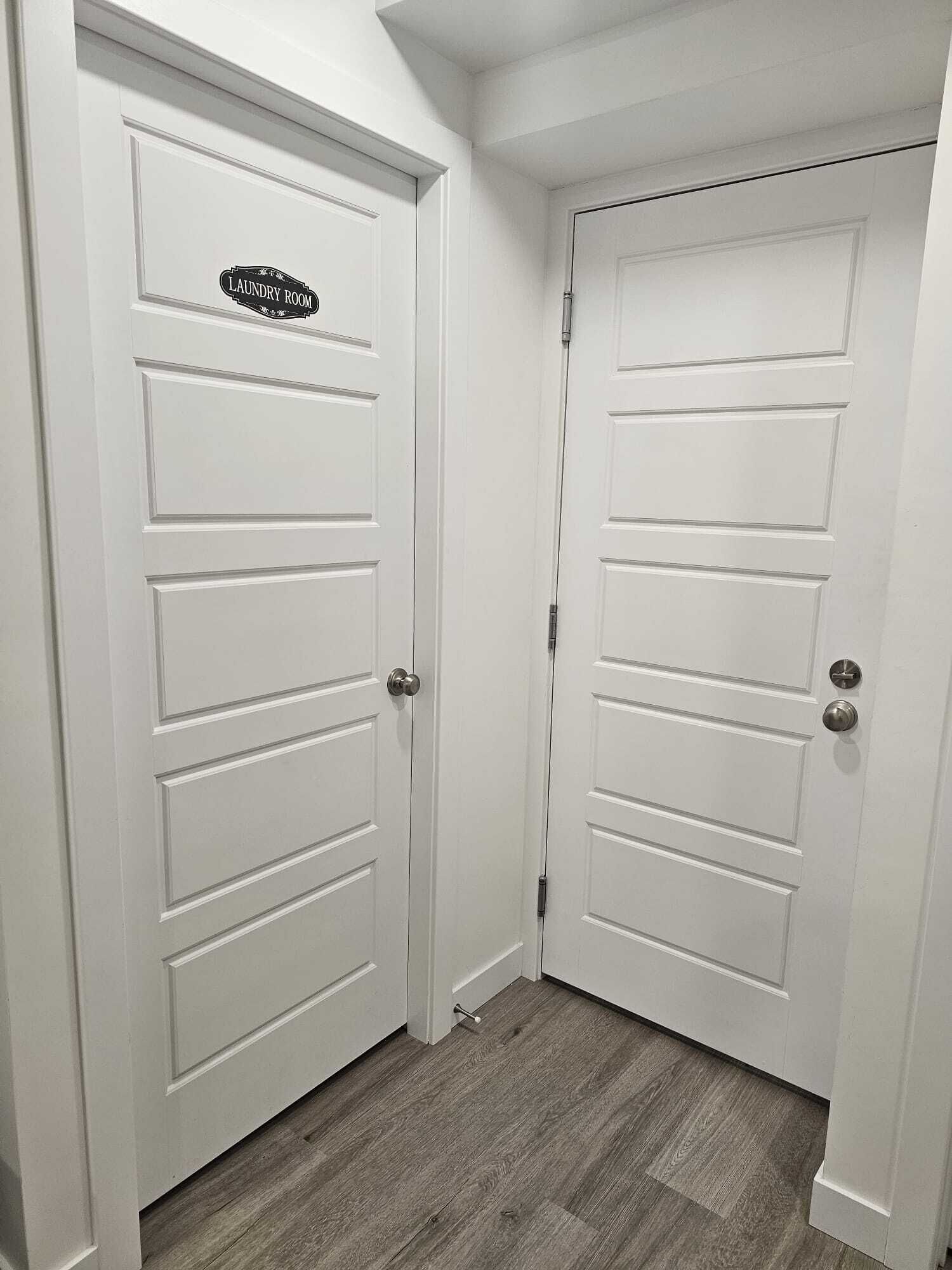 A hallway with two white doors, one labeled "Laundry Room."