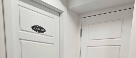 A hallway with two white doors, one labeled "Laundry Room."