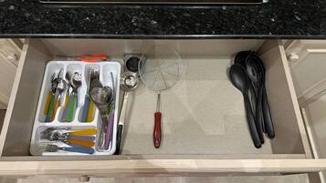 A kitchen drawer with utensils, a whisk, and a spatula.