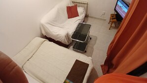 A small, compact room with a bed, a small table, and a television. - Exterior Double Room Toledo (Toledo)