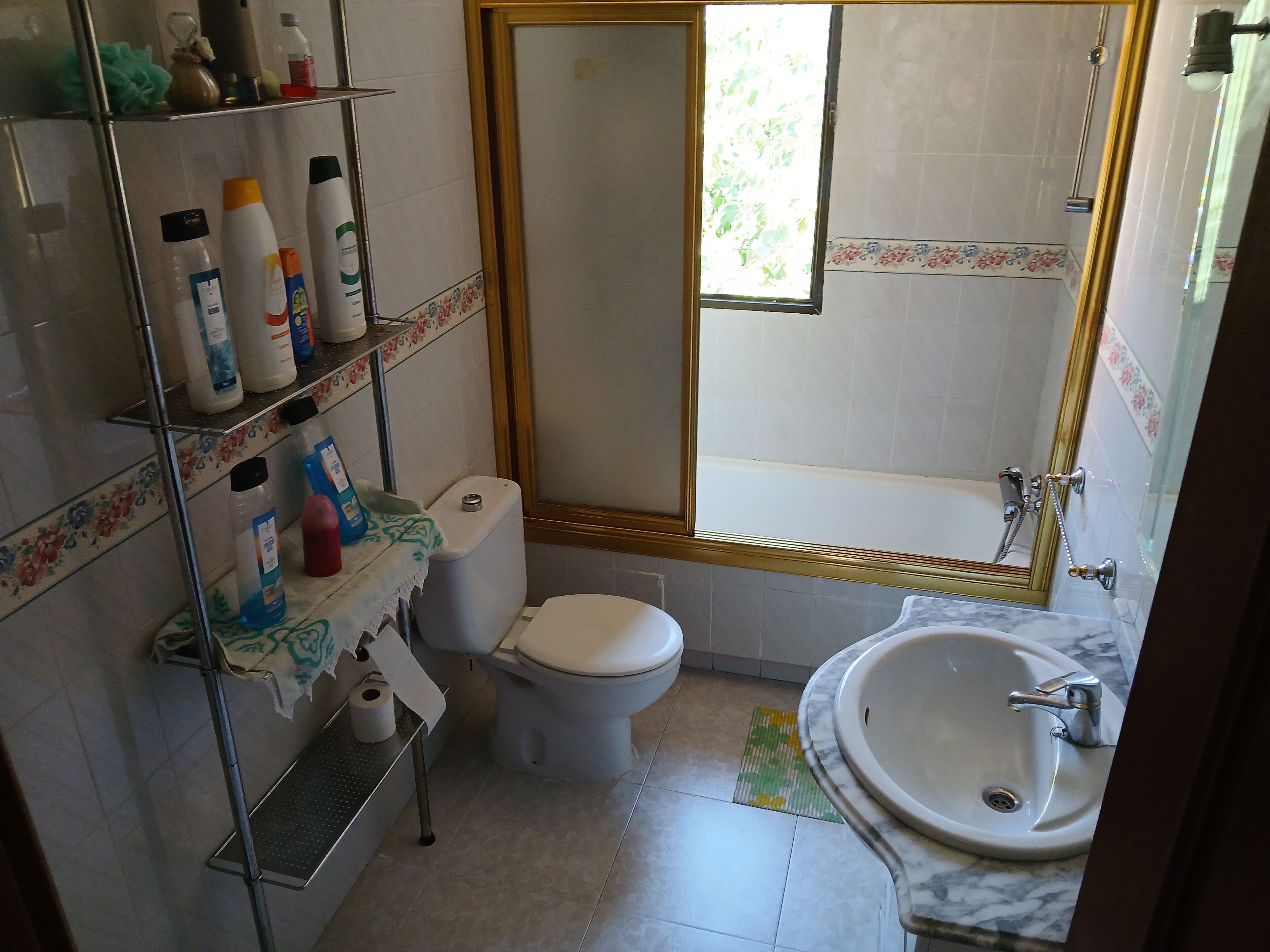 A bathroom with a toilet, sink, and shower area.