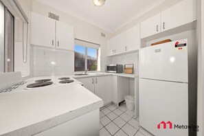 Een koelkast, een magnetron, een kookplaat, een broodrooster