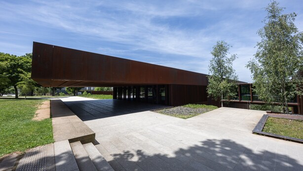 A modern building with a flat roof, large open space, and a paved area with a small garden. - Le Cyclactus (ex-Cyclamens) - Rodez-Onet (Onet le Château)