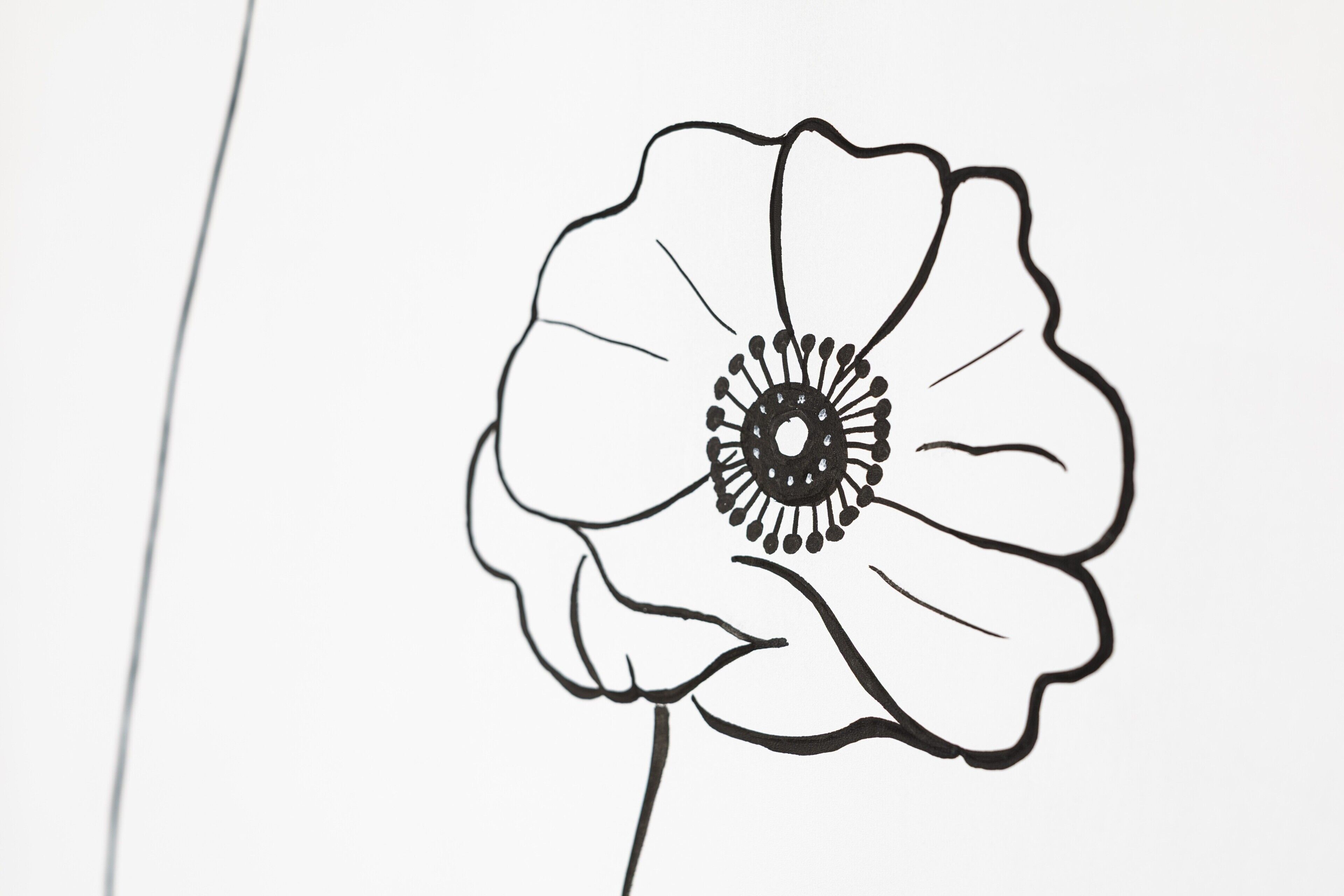 Un dessin linéaire représentant une fleur, avec un centre détaillé et des pétales.