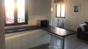 Une cuisine moderne équipée d’un four à micro-ondes, d’une table à manger et d’une fenêtre.