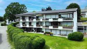 A modern multi-story hotel with balconies, outdoor seating, and well-maintained gardens. - Apartment 'Schönblick' in a Quiet Location with Beautiful Views, Indoor Pool (Höchenschwand)