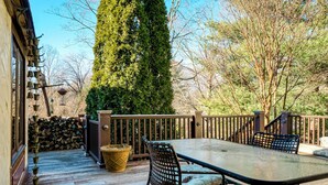 A deck with a table and chairs, surrounded by a wooden fence and a tall tree. - Highland Ave (Norwalk)