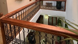A multi-level interior with a central open space, a wooden railing, and decorative lighting fixtures. - Riad Louzaia Marrakech (Marrakech)