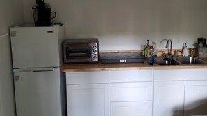 Eine kleine Küche mit Kühlschrank, Toastern und Spüle.