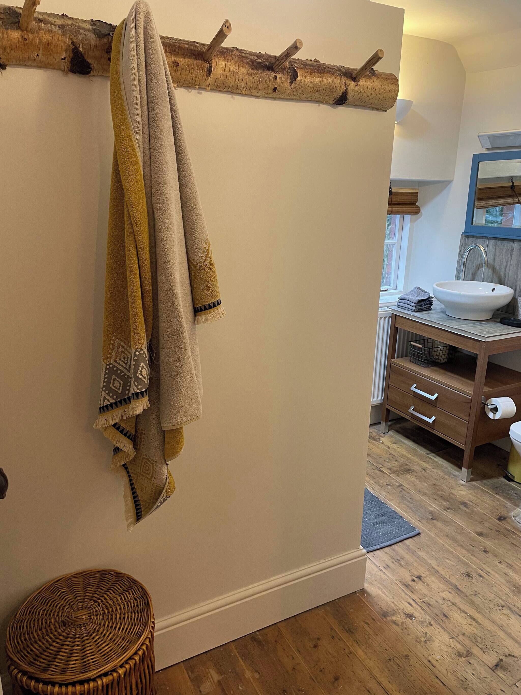 A bathroom with a wooden floor, a white sink, and a mirror above the sink.