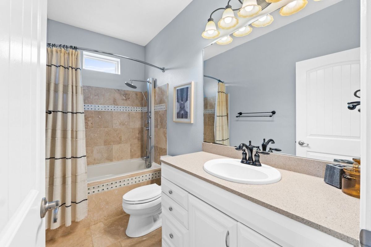 A bathroom with a shower, toilet, and sink.