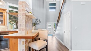A kitchen with a wooden countertop, a built-in brick backsplash, and a clock on the wall. - Good Vibes: New Mgmt 2026, Relaxing Private Escape w/ Pool & Beach Service (Destin)