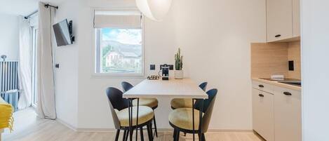 Een moderne keuken met een eettafel, stoelen en een raam.