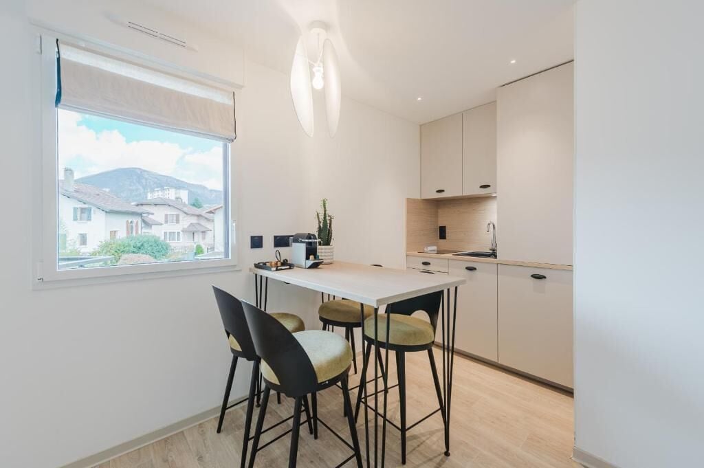 Una cocina moderna con comedor, una ventana con vistas y una lámpara colgante.