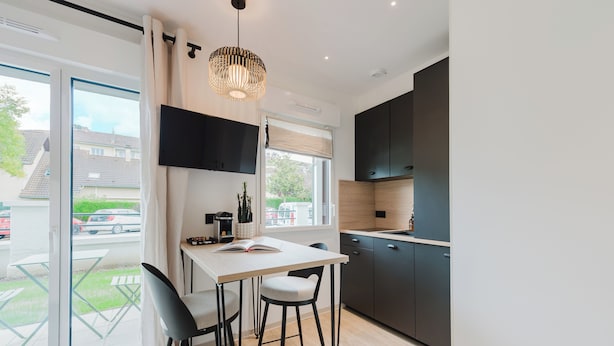 A modern kitchen with a dining area, a large window, and a view of the outside. - Neostelia (Annecy)