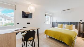 A modern bedroom with a bed, a desk, and a chair.