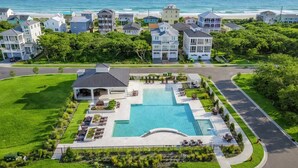 A resort with a large swimming pool, beachfront villas, and a well-maintained lawn. - The Jolly Gator #212 Resort Pool, Private Hot Tub, Elevator, Game Room (Surf City)