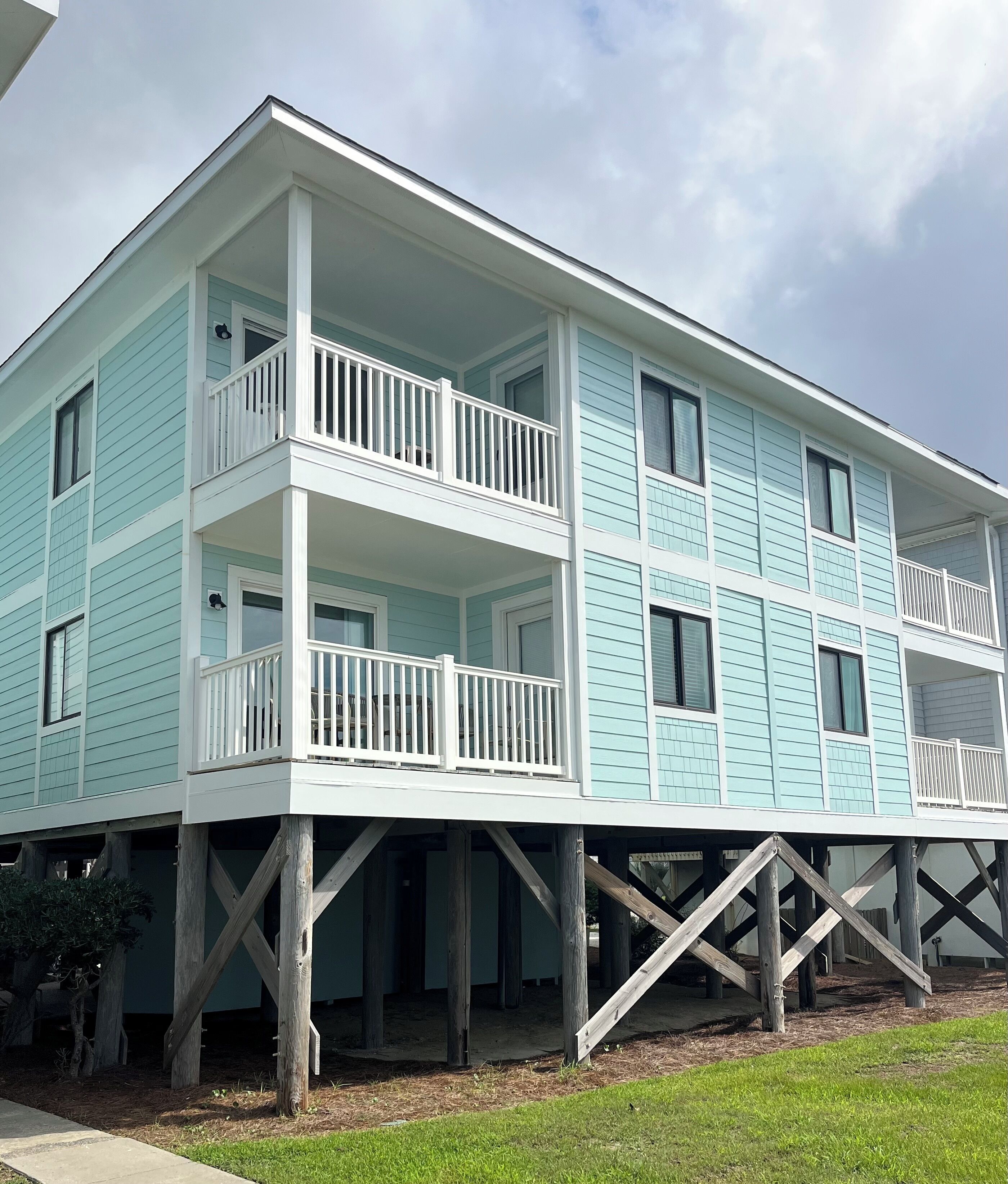 A two-story building with a balcony on the upper floor, supported by wooden stilts.
