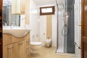 A bathroom with a sink, toilet, bidet, and a glass-enclosed shower. - Villa Serena - Alghero (Alghero)
