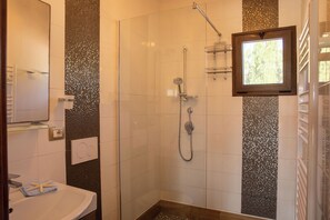 A shower with a handheld showerhead, a glass-enclosed shower, and a window above the shower. - Villa Serena - Alghero (Alghero)