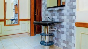 A bathroom with a modern sink, a mirror, and a tiled wall. - Fabulous 4BDR villa with a jacuzzi in exciting Kigali Kimironko for your getaway (Kigali)