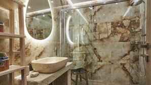 A modern bathroom with a large marble sink, a glass-enclosed shower, and a wooden stool. - Porto Santo Mani 1st Apartment (Mani)
