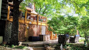 A wooden balcony with a lattice design, a stone bench, and a statue.