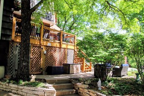 A wooden balcony with a lattice design, a stone bench, and a statue. - This home is an escape with little traffic, quiet neighbors, & large yards. Enjoy the peace & quiet by Home Heart Home (Shawnee)