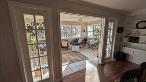 A spacious living area with a large window, a ceiling fan, and a cozy seating arrangement.