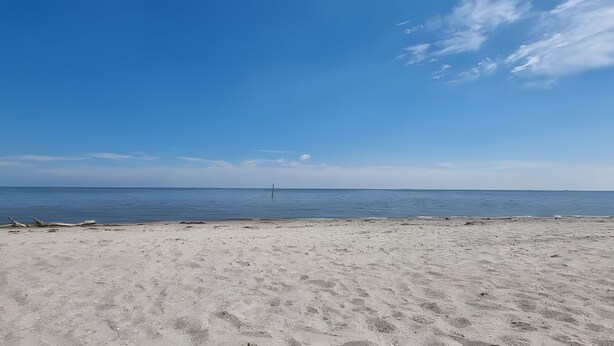 A beach with a clear sky and calm sea. - Apartment 'Am Meer Nordsee' with Shared Garden, Balcony & Wi-Fi (Wangerland)