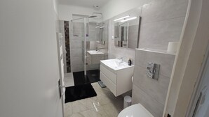 A modern bathroom with a glass shower enclosure, a white sink, and a toilet. - DETACHED BUNGALOW AT THE BACK OF OUR 2-STAR VILLA (Fréjus)