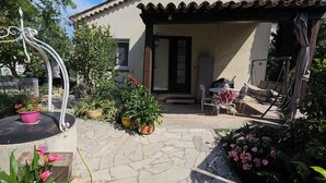 A house with a tiled patio, potted plants, and outdoor furniture. - DETACHED BUNGALOW AT THE BACK OF OUR 2-STAR VILLA (Fréjus)