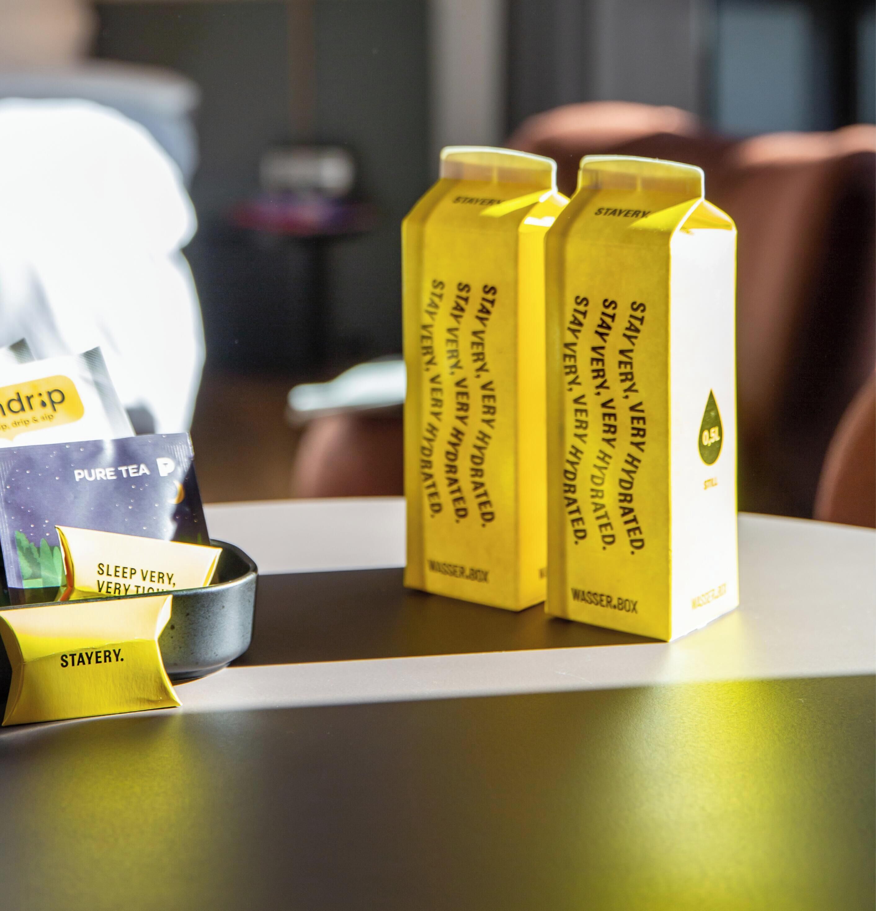 Un espace dédié au café, avec des sachets de café et une tasse à café, tous aux couleurs de la marque.