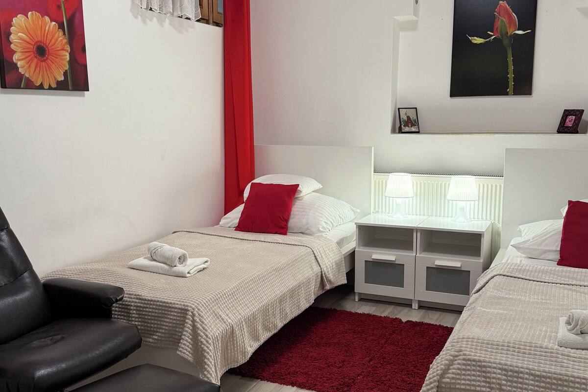 Ein Hotelzimmer mit zwei Betten, einem Schreibtisch, einem Stuhl und einer Heizung.