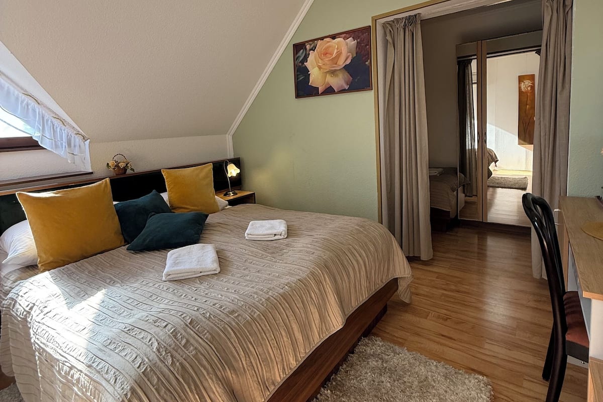 Ein Schlafzimmer mit einem großen Bett, einem Nachttisch, einem Schreibtisch und einem Stuhl.