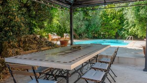 An outdoor patio with a pool, surrounded by lush greenery. - Villa Quercia - Valbonne (Valbonne)