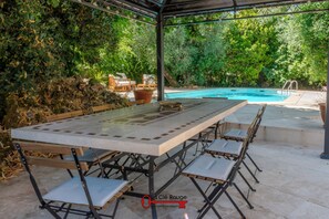 Eine Außenpatio mit Pool, umgeben von üppigem Grün.