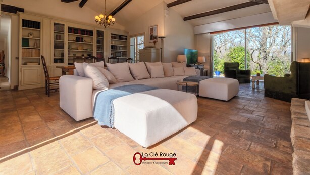 A spacious living area with a large sectional sofa, a fireplace, and a view of the outdoors. - Villa Quercia - Valbonne (Valbonne)