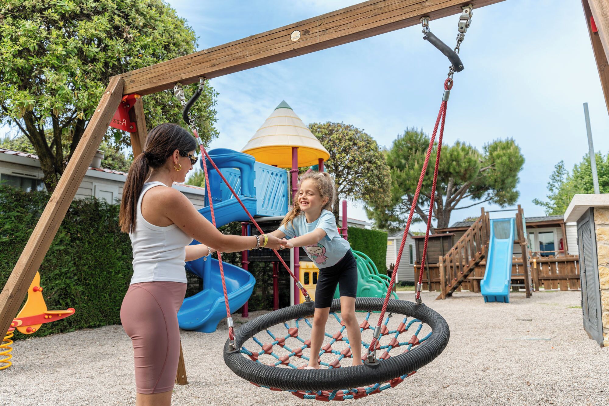 A playground with a swing set, a slide, and a climbing structure.