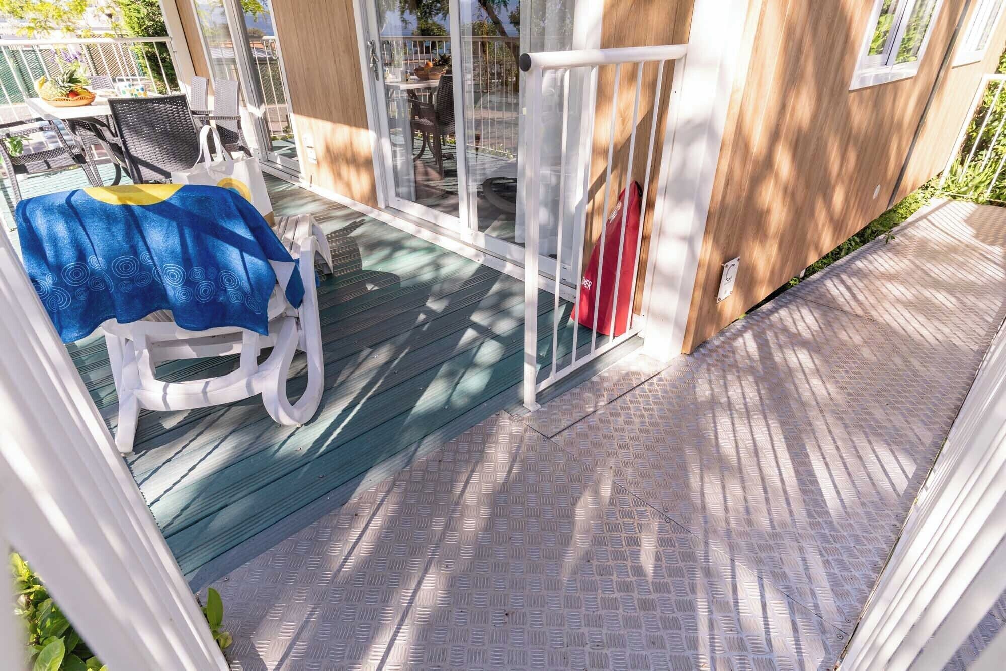 Un espacio al aire libre cubierto con una mesa de patio y sillas, una puerta corrediza de vidrio y una terraza de madera.