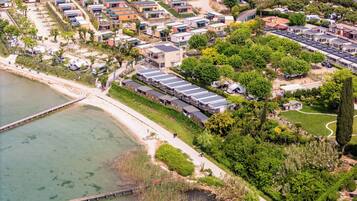 An aerial view of a coastal residential area with modern houses, a marina, and a bridge.